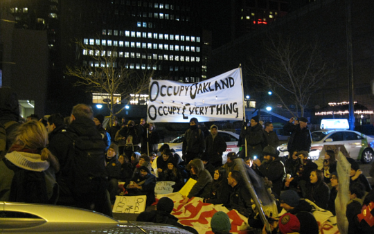 Occupy Boston marchers sitting down in the street in front of the Prudential Center